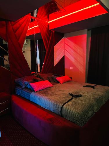 a room with a bed with red lights on it at Nowad Hotel in Giurgiu