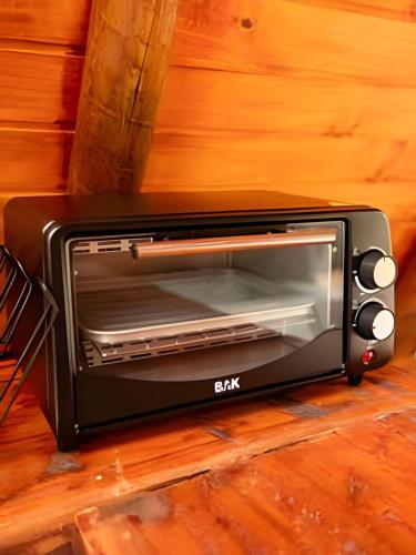 a black toaster oven sitting on a wooden floor at Espaço Gaia in Santana do Riacho