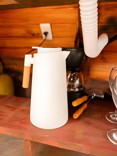 a white coffee pot sitting on top of a table at Espaço Gaia in Santana do Riacho