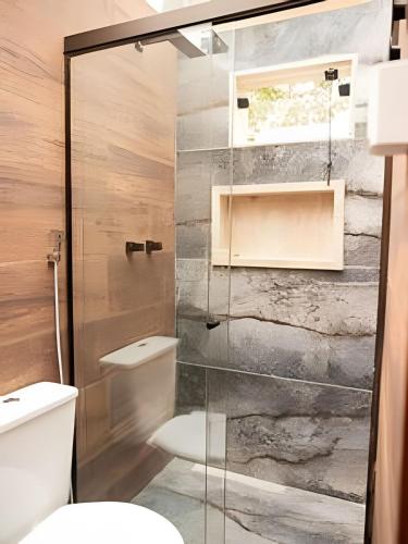 a bathroom with a toilet and a glass shower at Espaço Gaia in Santana do Riacho