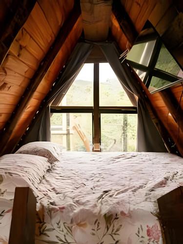a bed in a room with a large window at Espaço Gaia in Santana do Riacho