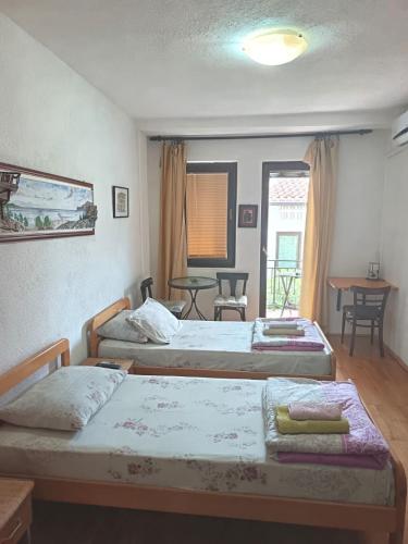 two beds in a room with a table and chairs at Villa Dudinka in Ohrid