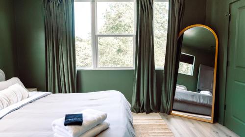 a bedroom with a bed and a large window and a mirror at ModTrio 3BR with ensuites & Garage Mins to Uptown in Charlotte