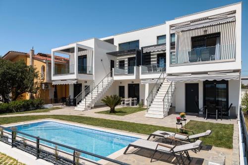 a house with a swimming pool in front of it at Olympiada Complex Calma Di Mare Apartment in Ofrínion