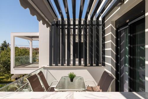a table and chairs on the balcony of a house at Olympiada Complex Calma Di Mare Apartment in Ofrínion