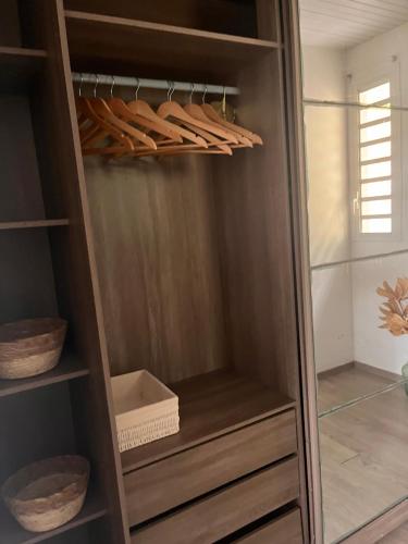 a closet with wooden shelves and wooden sticks in it at L'Écrin du colibri, a haven of peace in Martinique in Le Robert