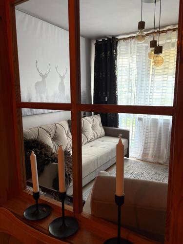 a living room with a couch and two candles at Przytulny Apartament in Ostrowiec Świętokrzyski