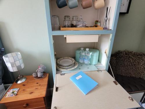 a cupboard with a table and a blue book on it at Felixstowe room lets in Felixstowe