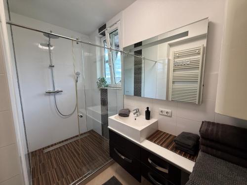 a bathroom with a sink and a shower with a mirror at Villa Komposch - adults only in Reifnitz