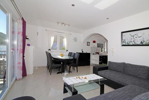a living room with a couch and a table at Apartment River Rose in Mokošica