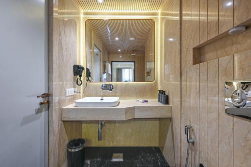 a bathroom with a sink and a mirror at Hotel Grand Girdhar Premier in Indore