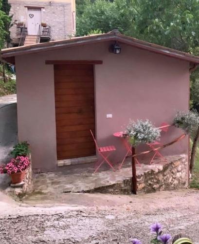 a garage with a bench in front of a house at la casetta delle more (monolocale) in Spoleto