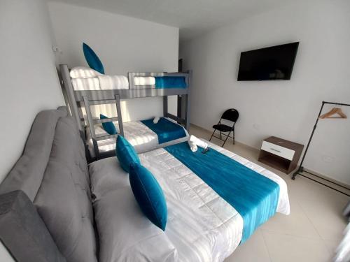 a bedroom with a bed and a couch with blue pillows at Hotel Santa Lucia in Socorro