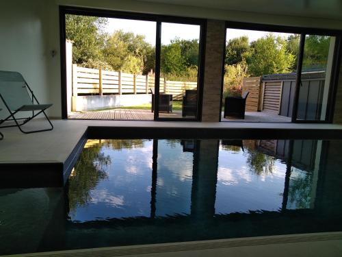 - une piscine avec une chaise à côté d'une maison dans l'établissement Maison bord de mer - Baie de Douarnenez - Piscine couverte, à PloÃ©ven