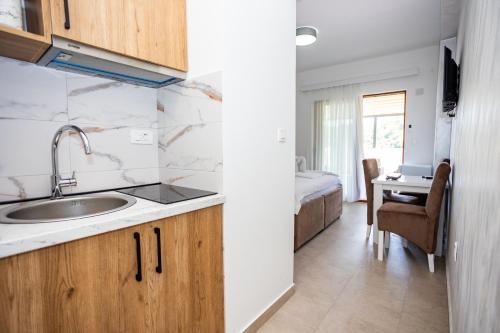 a kitchen with a sink and a bedroom with a bed at Apartmani Milos - Meljine in Herceg-Novi