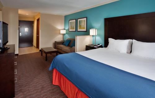 Una habitación de hotel con una cama grande y un sofá. en Holiday Inn Express Hotel & Suites North Kansas City by IHG, en Kansas City