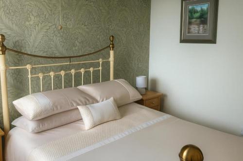 a bed with white pillows on it in a bedroom at The Boughton Peterchurch - Pub Grub & Bed in Peterchurch