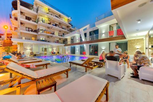 a group of people sitting around a pool in a building at Lotos - stan 423 in Dobra Voda