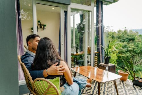 a man and a woman sitting at a table on a porch at Casa Ejecutiva Boquete in Boquete