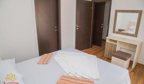 a bedroom with a white bed with a mirror at Lotos - stan 423 in Dobra Voda