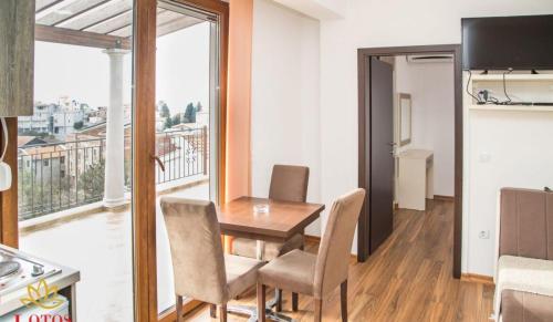 a dining room with a table and chairs and a balcony at Lotos - stan 423 in Dobra Voda