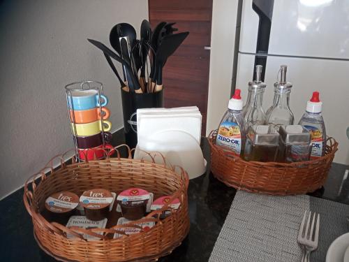 two baskets on a counter with bottles and utensils at Apê Aconchego Calhau - 3 Minutos de Carro da Praia in São Luís