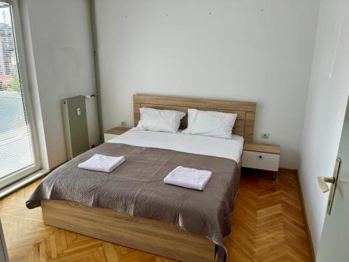 une chambre avec un lit avec deux serviettes dessus dans l'établissement Modern Flat in Prishtina Centre, à Pristina