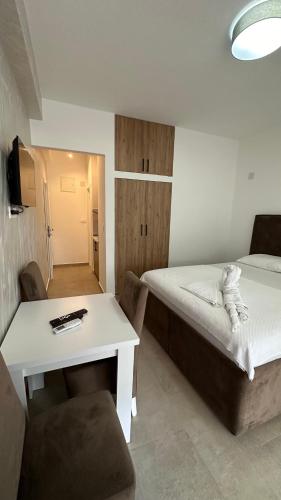 a small room with a bed and a table and a desk at Apartmani Milos - Meljine in Herceg-Novi
