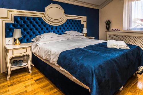 a bedroom with a large bed with a blue headboard at Sky Park Home 2 in Iaşi