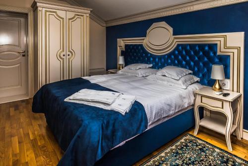 a blue bedroom with a king sized bed and a table at Sky Park Home 2 in Iaşi