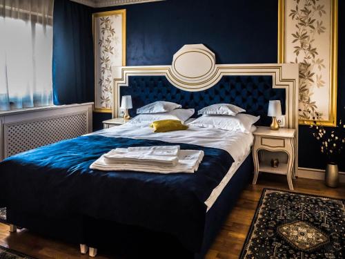 a blue bedroom with a large bed with a blue headboard at Sky Park Home 2 in Iaşi