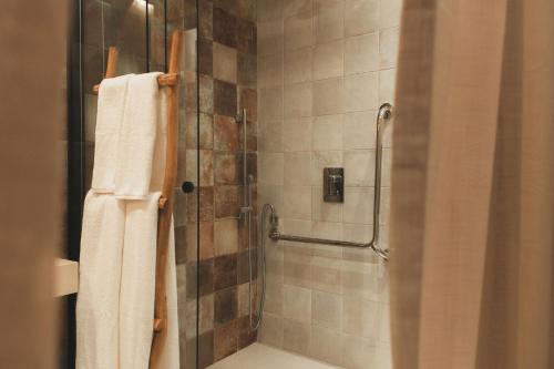 a bathroom with a shower with a glass door at Pousada Casa Mandacaru Noronha in Fernando de Noronha
