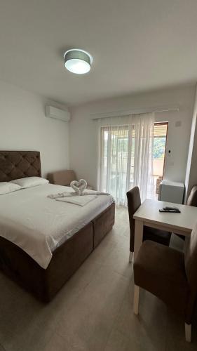 a bedroom with a bed and a table and a chair at Apartmani Milos - Meljine in Herceg-Novi