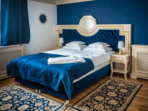 a blue bedroom with a bed with a blue headboard at Sky Park Home 2 in Iaşi