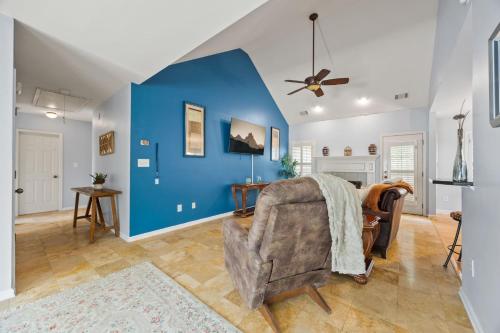 a living room with a blue wall and a chair at Relaxing 3BR Duplex Home w/ Pool & Patio in Buford