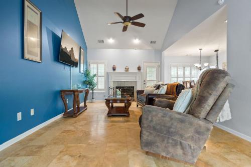 a living room with blue walls and a ceiling fan at Relaxing 3BR Duplex Home w/ Pool & Patio in Buford