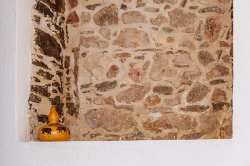 a small yellow jar sitting in front of a stone wall at Domm'e Antoni in Baunei