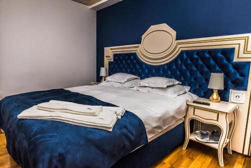 a blue bedroom with a bed with a blue headboard at Sky Park Home 2 in Iaşi
