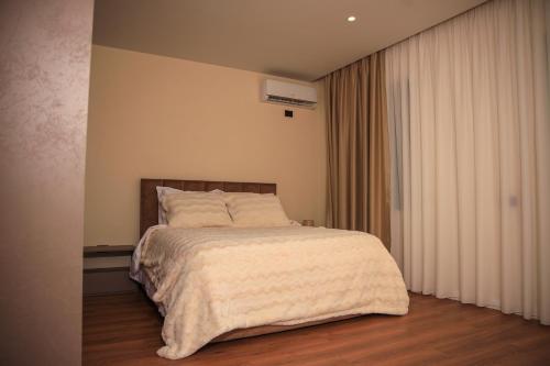 a bedroom with a bed with a white comforter at Greco Boutique Hotel in Shkodër