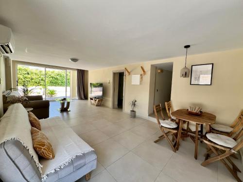 a living room with a couch and a table and chairs at Pool Villa Lagonisi 5min from Beach in Koropíon