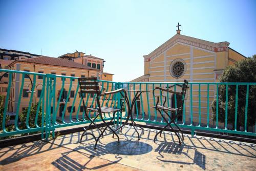 a fence with two chairs in front of a church at Greco Boutique Hotel in Shkodër