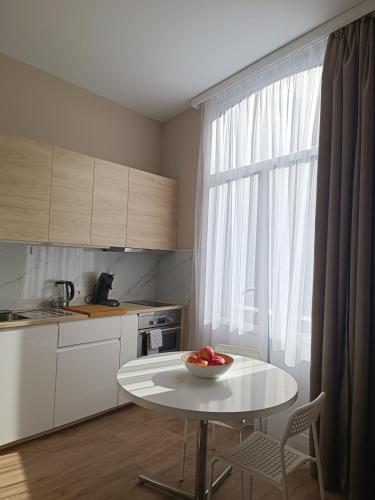 Una cocina con una mesa con un bol de fruta encima. en AppartCosy, en Mellet
