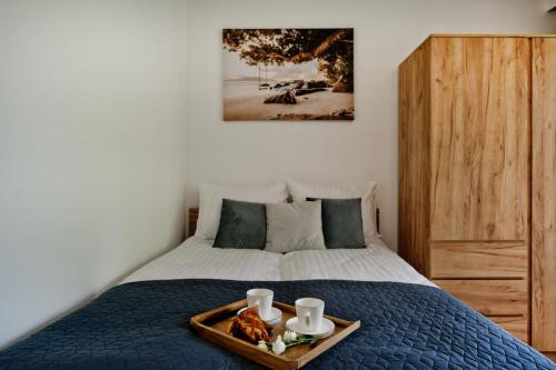 a bedroom with a bed with a tray of food on it at Casa Baia BlueApart Hel in Hel