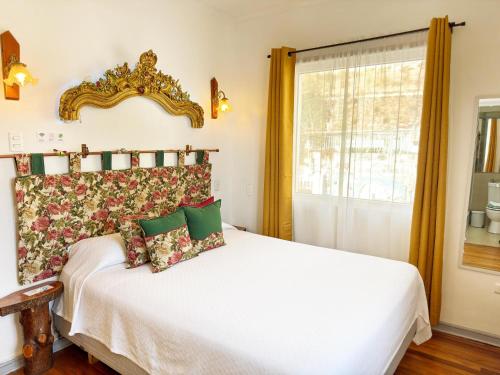 a bedroom with a bed and a mirror on the wall at AYCA La Flora Hotel Boutique in Valparaíso