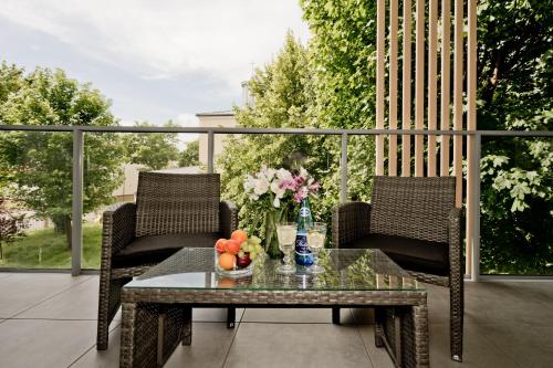 a patio with two chairs and a table with flowers at Casa Baia BlueApart Hel in Hel