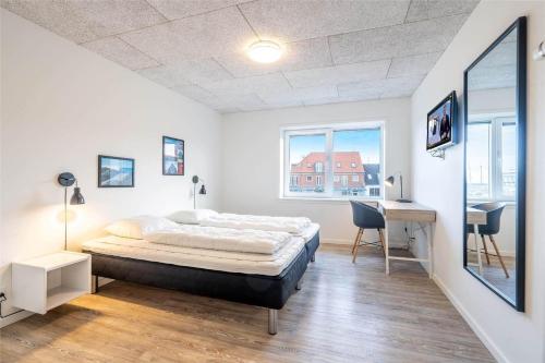 a bedroom with a bed and a desk in it at 804-Hvide-Sande-Havnegade-2-1-A in Hvide Sande