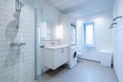 a white bathroom with a sink and a washing machine at 804-Hvide-Sande-Havnegade-2-1-A in Hvide Sande