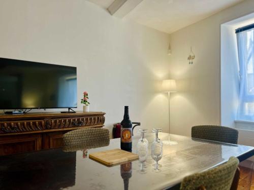 a table with a bottle of wine and glasses on it at The Duplex des Flots In the heart of Grandcamp just steps from the beach in Grandcamp-Maisy