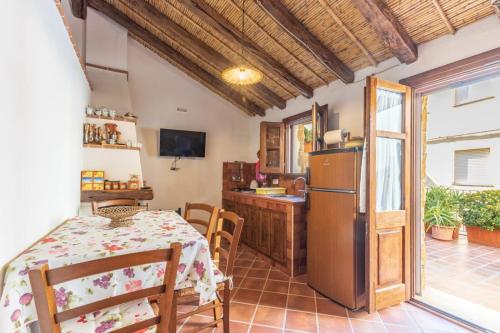 a kitchen and dining room with a table and a refrigerator at Domm'e Antoni in Baunei
