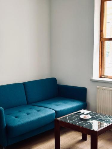 a blue couch in a living room with a coffee table at Sunlit Apartment with Garden, Next to Station, Vienna in Vösendorf